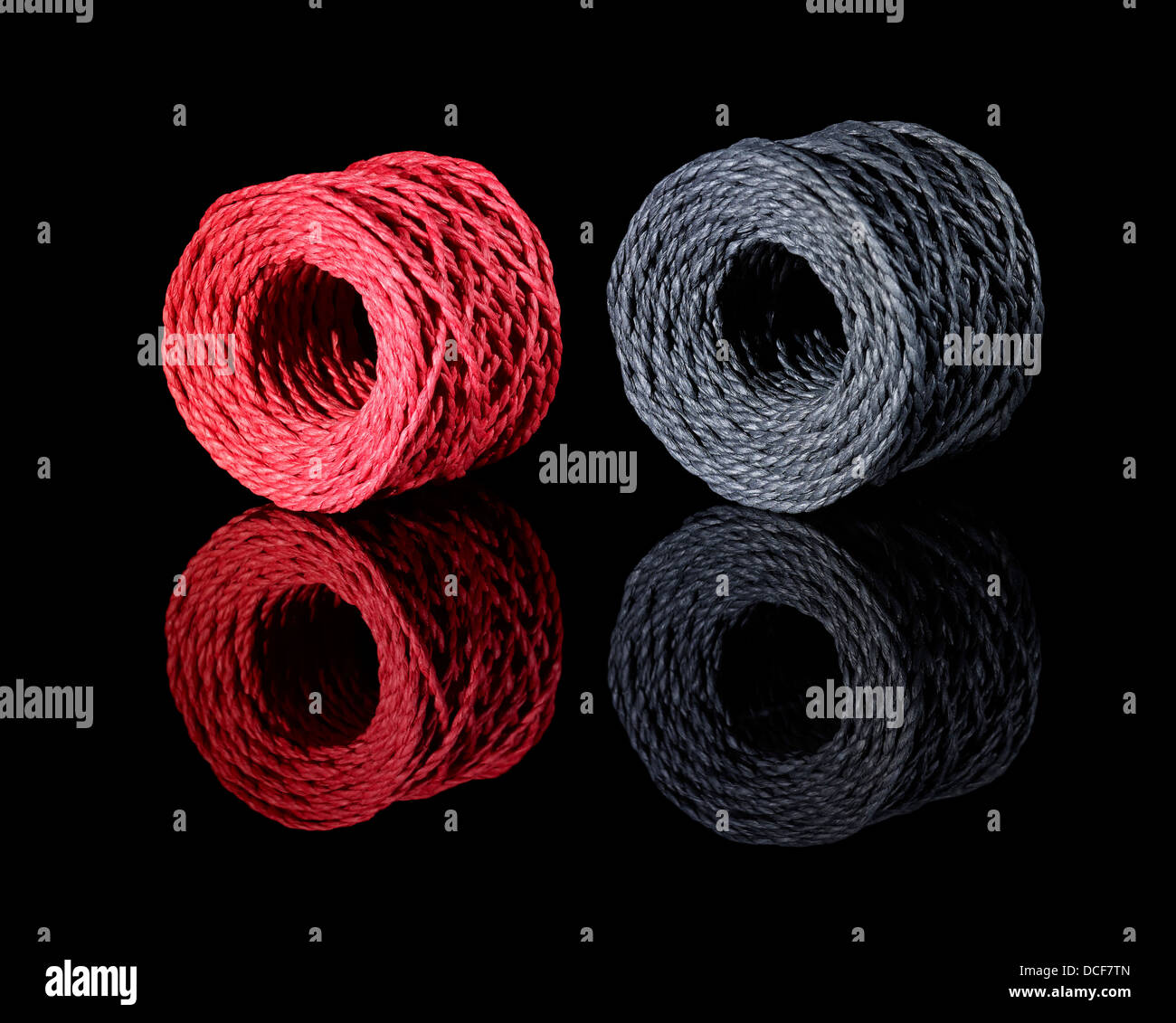 a red and a dark grey string coil in black reflective back Stock Photo ...