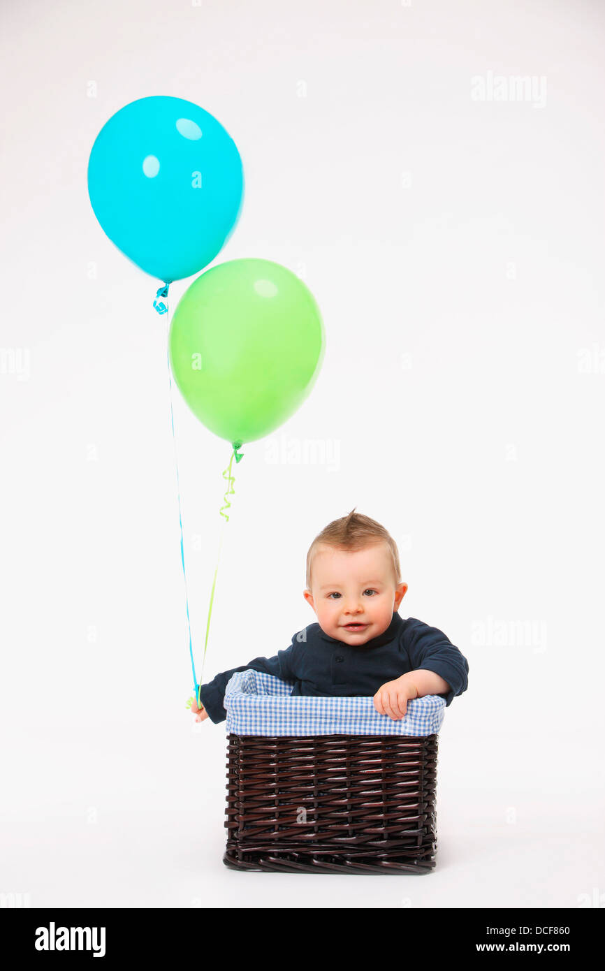 Boy In A Basket With Balloons Stock Photo - Alamy
