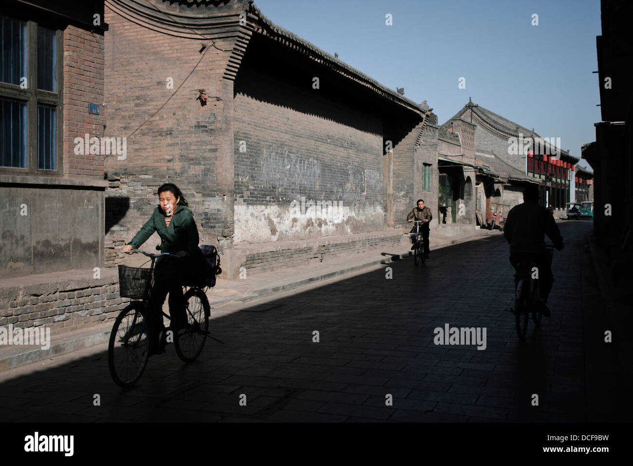 Street scene in Ping Yao, China. People cycling. Stock Photo