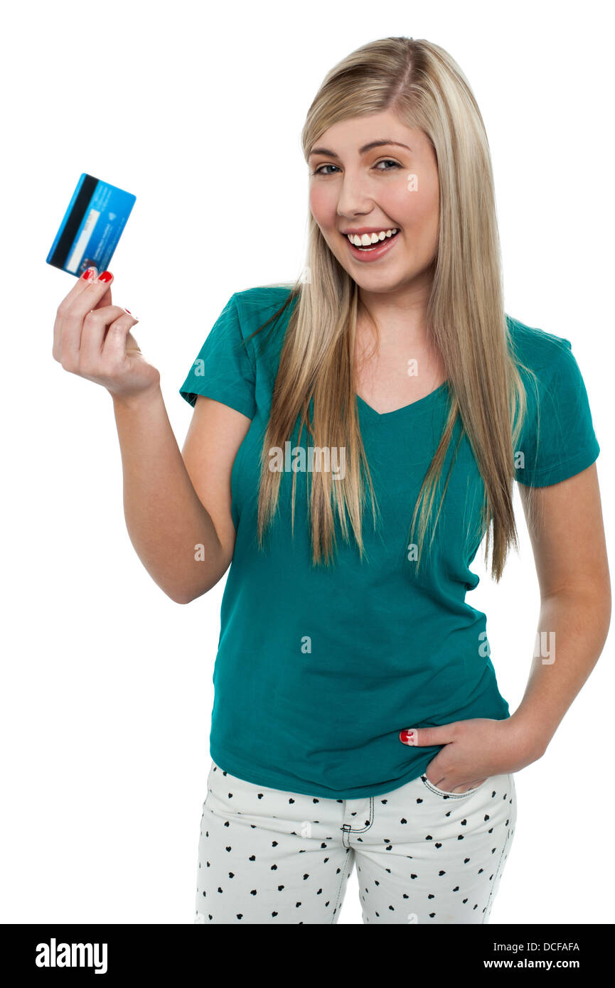 Cheerful teenage girl holding up her cash card, looking excited Stock