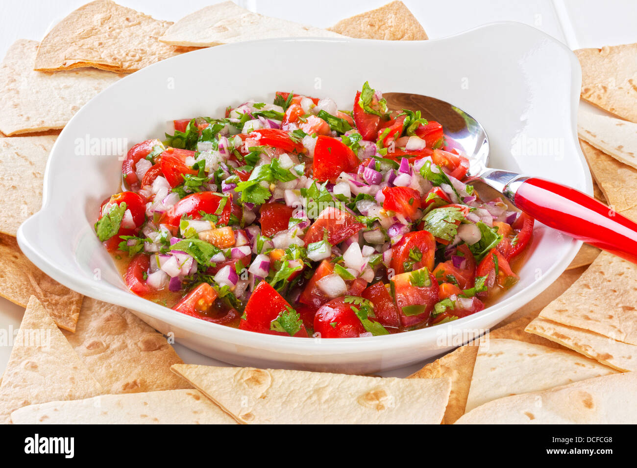 Pico de gallo, or salsa fresca, is a fresh, uncooked relish in Mexican cuisine, made from tomatoes, red onion, chilli, olive... Stock Photo