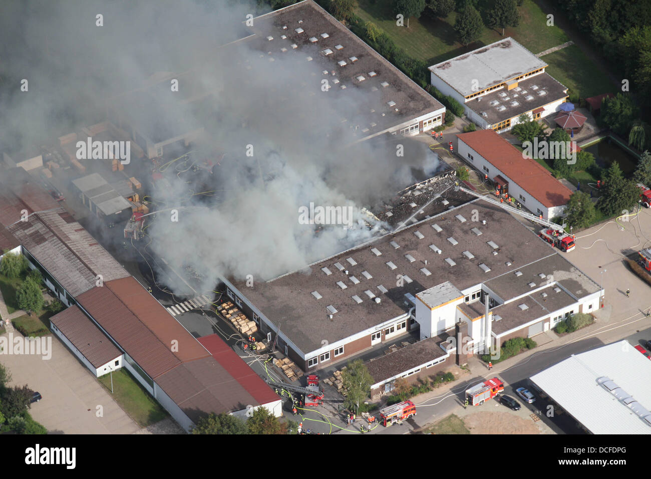 Dassel, Germany. 16th Aug, 2013. Dense smoke rises from a building of