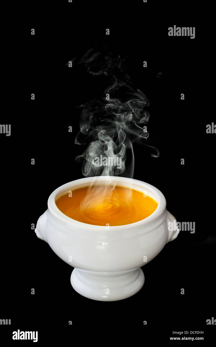Pumpkin Soup - a bowl of steaming hot pumpkin soup, in a lion head bowl, on a black background, front to back focus... Stock Photo