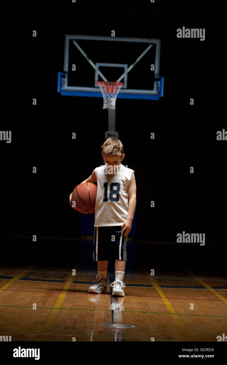 Young Boy Standing On Basketball Court Looking Solemn Stock Photo - Alamy