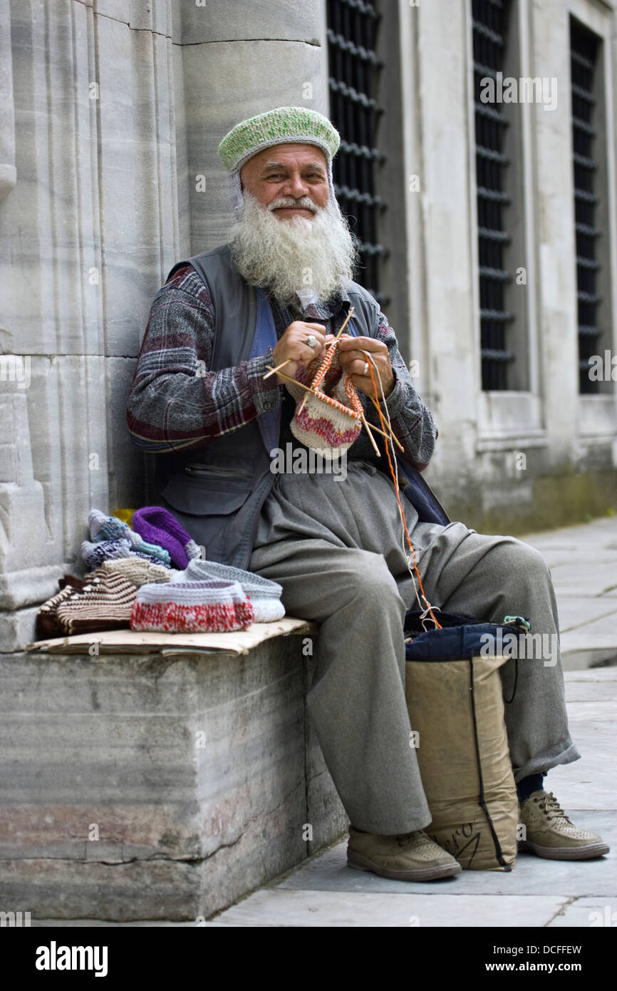 Man Knitting Outdoors In Asia Stock Photo