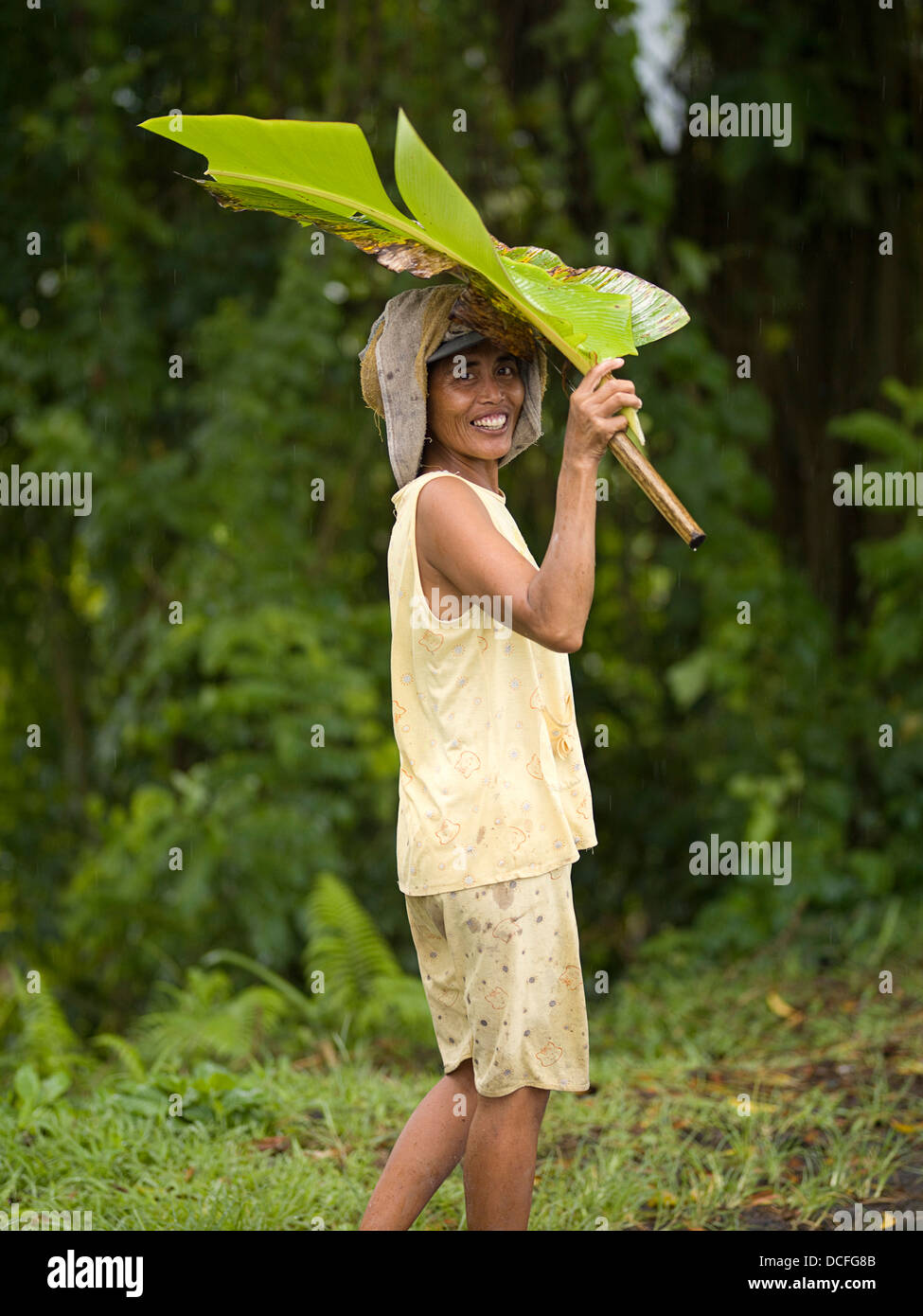 Woman Holding Leaf Over Head In Bali Stock Photo - Alamy