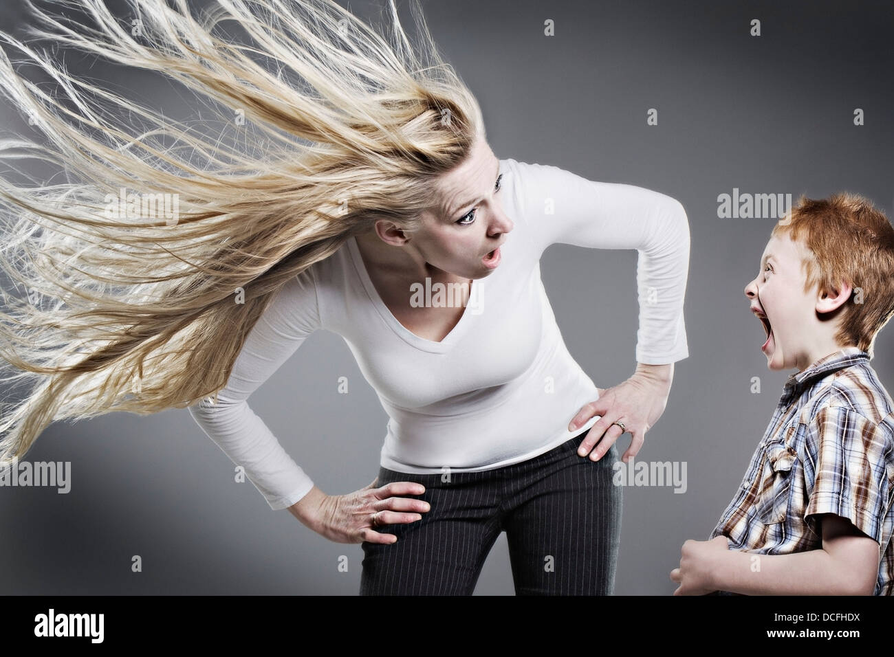 Mother Yelling At Son As Her Hair Blows Wildly Stock Photo