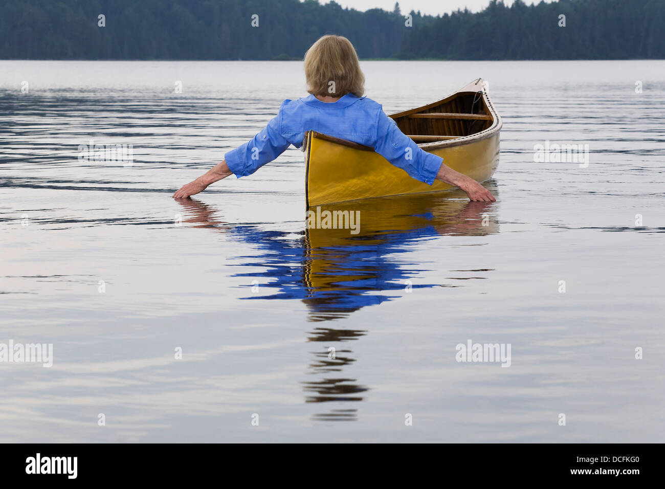 Woman In Canoe Trailing Hand In Water, Algonquin Park, Ontario, Canada Stock Photo
