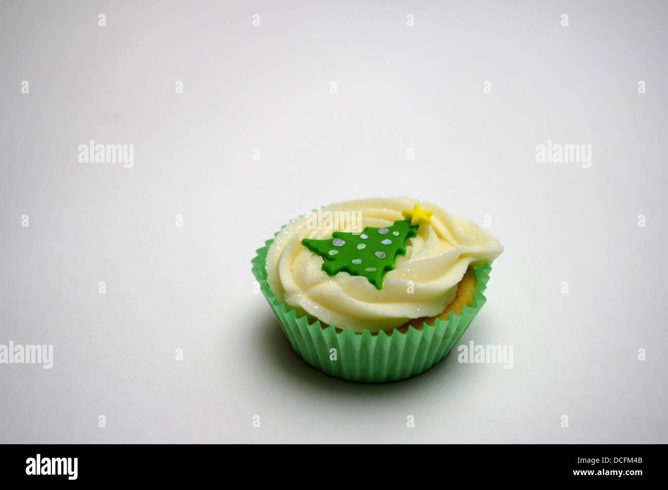 Single cup cake with icing Christmas tree on white background, copyspace Stock Photo