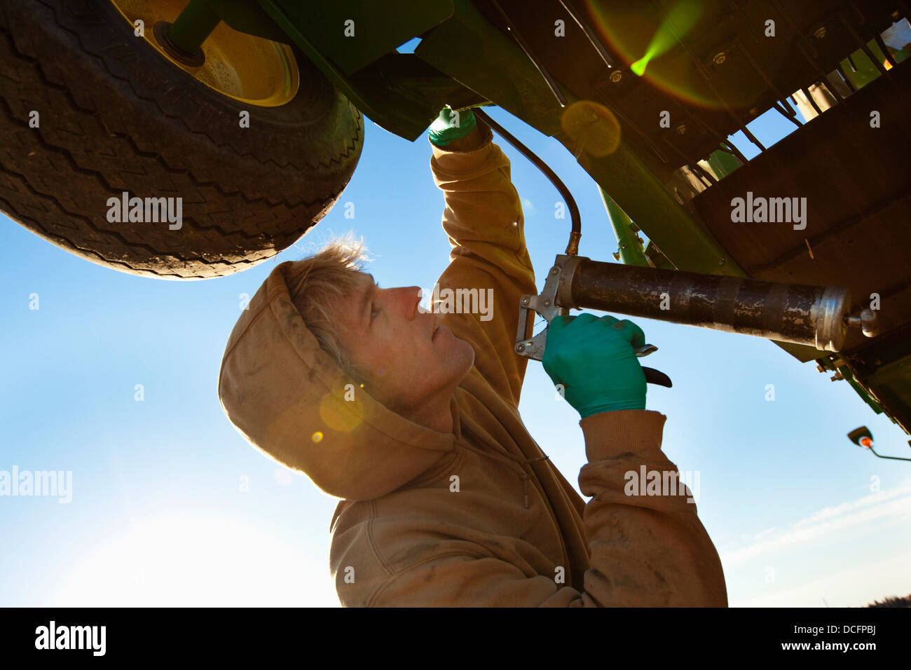 A Person Works On Farm Equipment; Three Hills, Alberta, Canada Stock