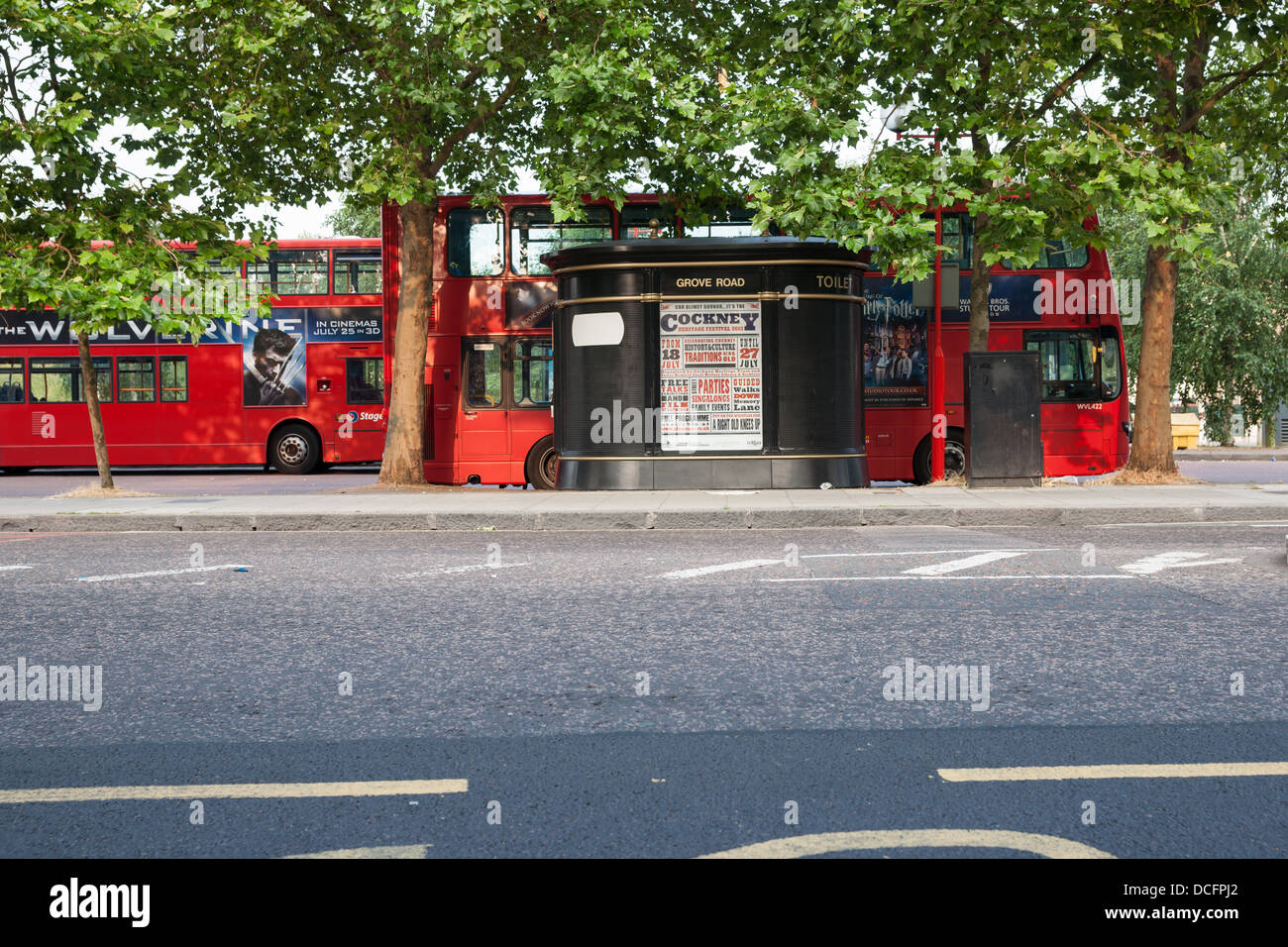 London, Grove Ropad bus stop with buses parked under trees and poster for the Cockney Heritage Festival in 2013. Stock Photo