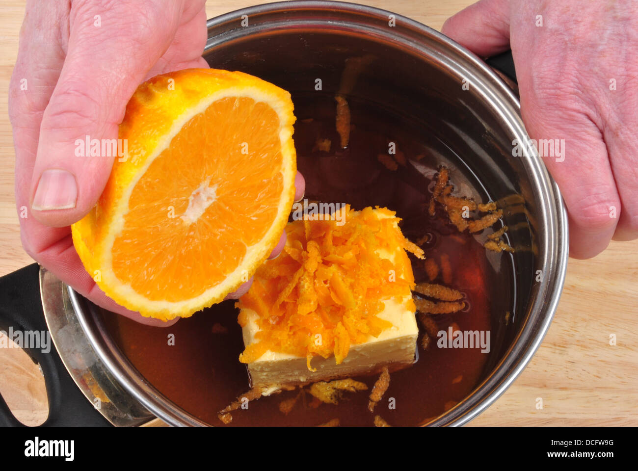 squeeze organic sweet orange juice in to a pot Stock Photo