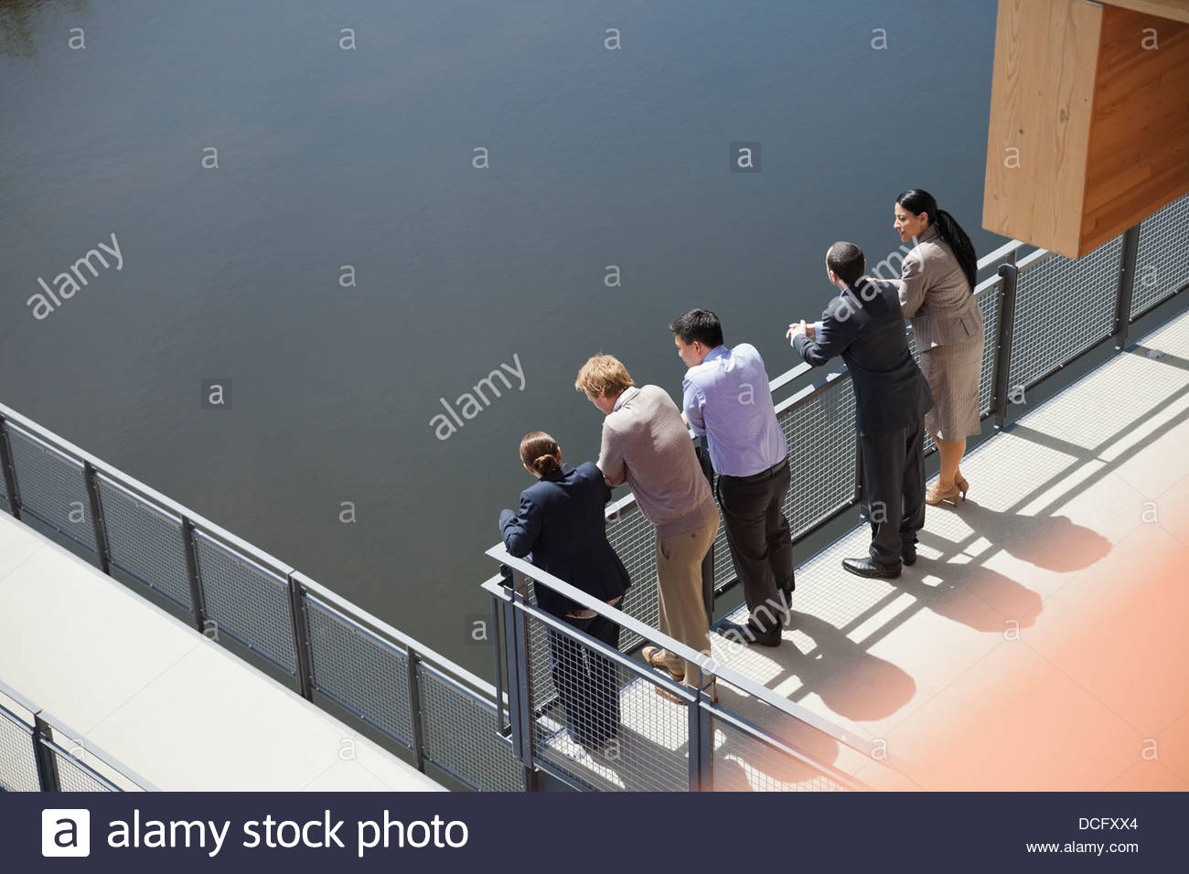 Business people standing in a line on balcony Stock Photo