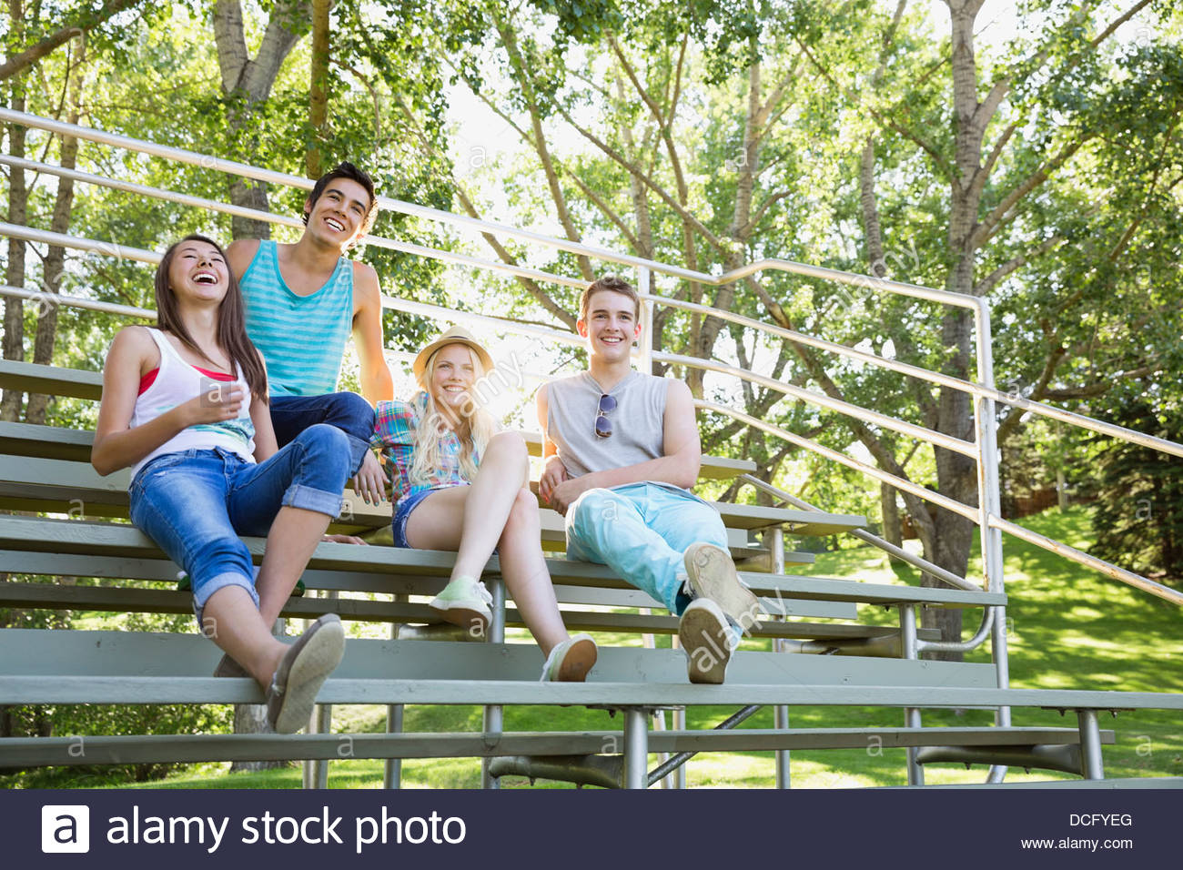 Teens sitting on bleachers in a park Stock Photo