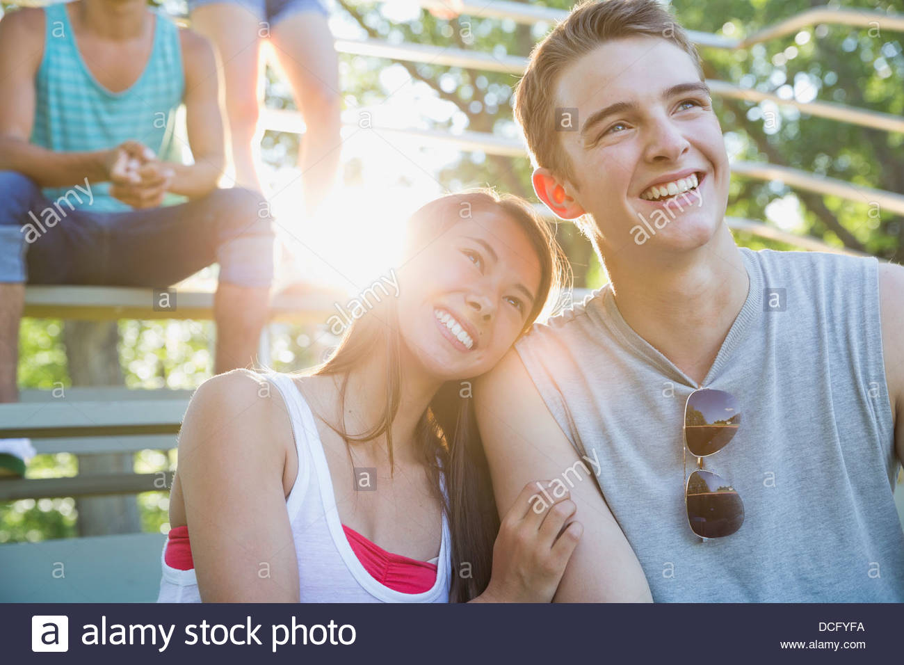 Teen couple sitting on park bleachers Stock Photo