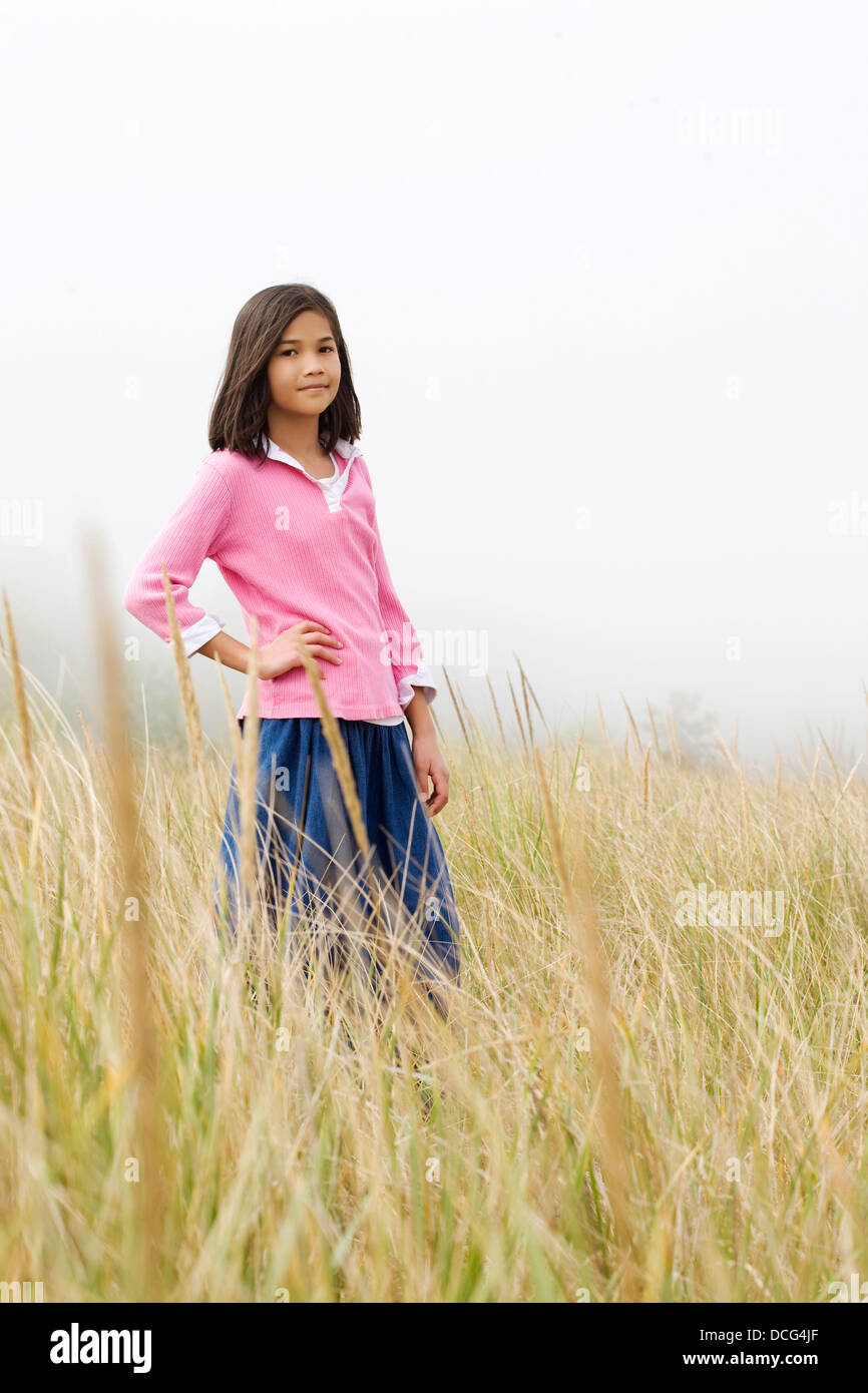 Girl standing in tall grassy field Stock Photo - Alamy
