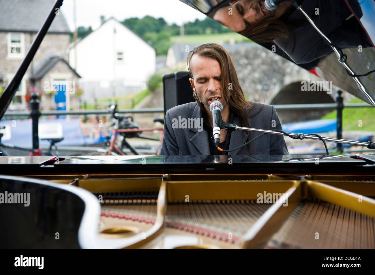 Pianist Ten Sheds playing piano entertaining crowds outside canalside during Brecon Jazz Festival Stock Photo