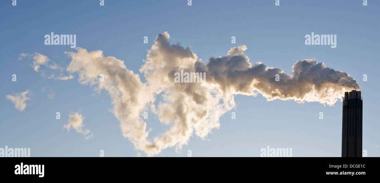 Smoking chimney against a blue sky Stock Photo - Alamy
