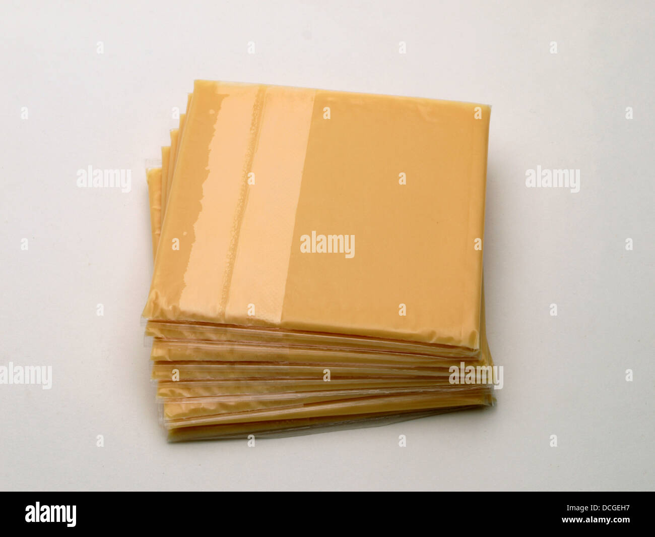 A stack of American cheese slices is laying on a white background Stock