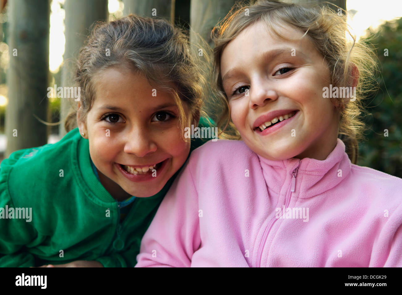 Portrait Of Two Girls Smiling Outdoors Stock Photo