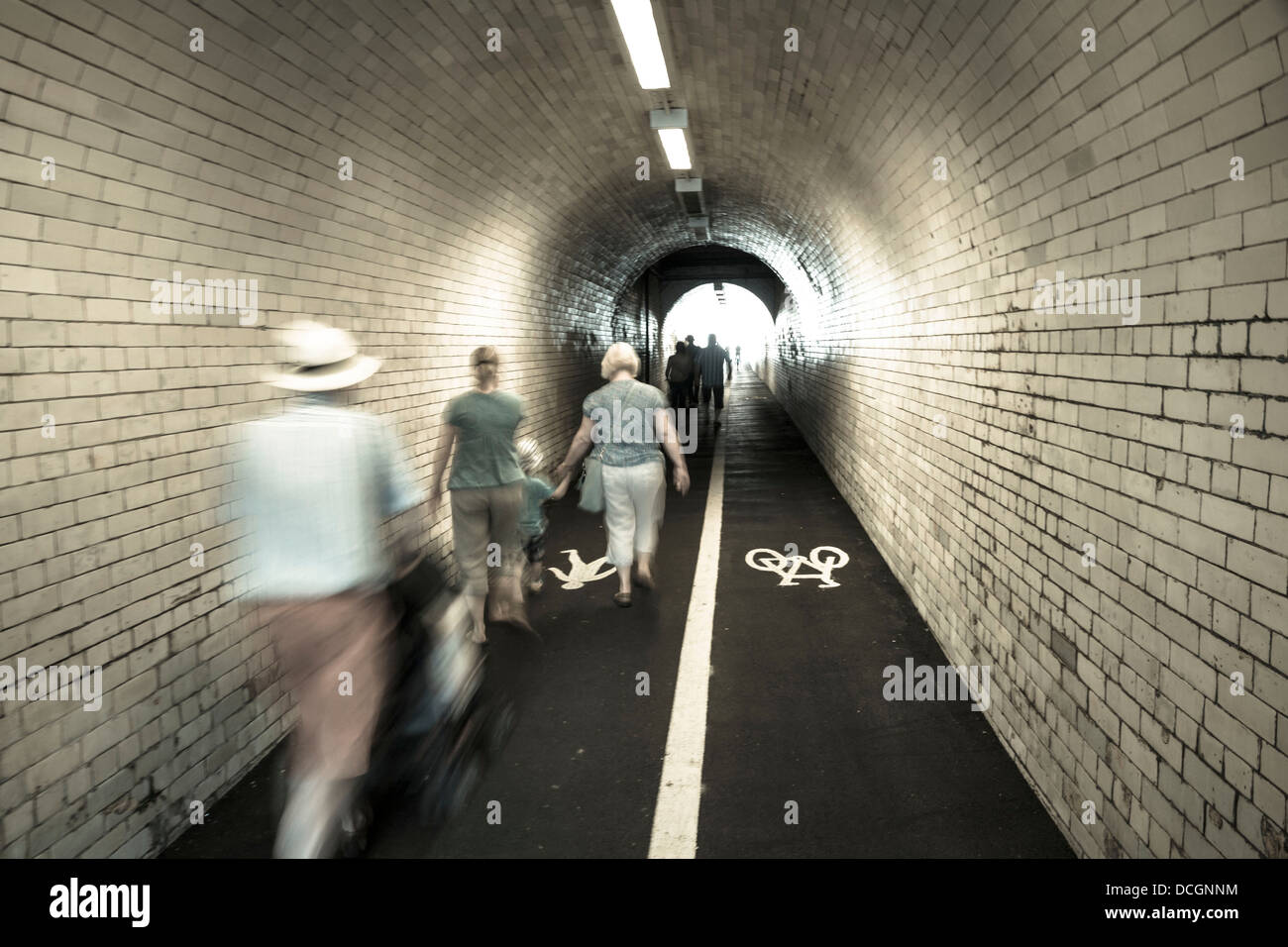 Blur blurred blurry movement motion people pedestrians walking through a tunnel underground tube underpass Stock Photo