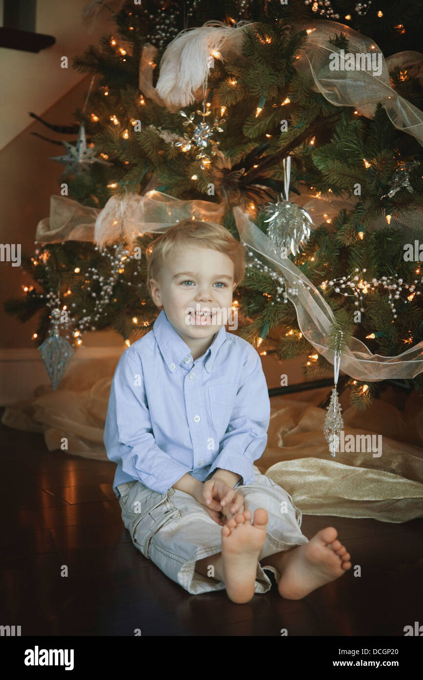 Toddler Sitting Beside Christmas Tree Stock Photo