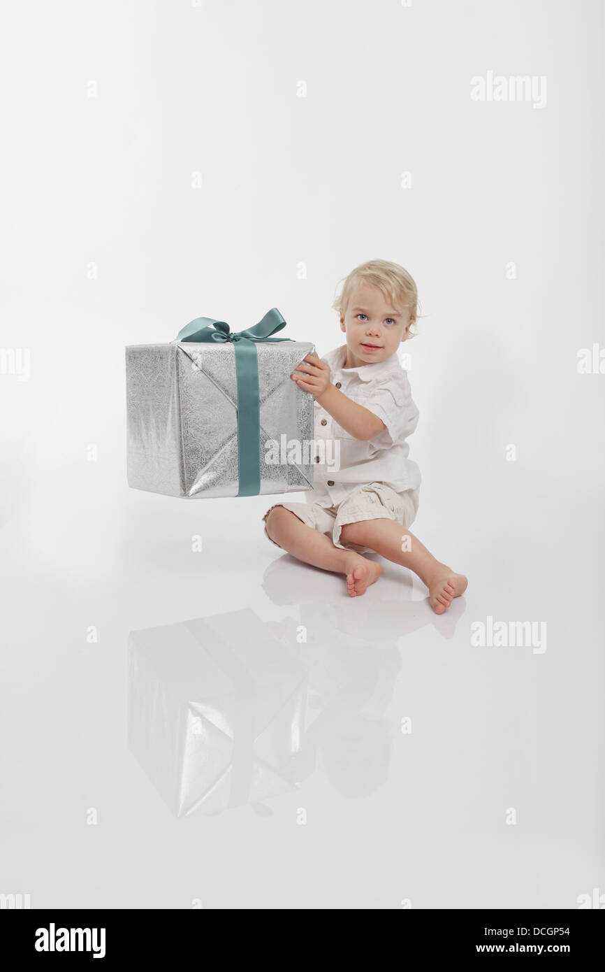 Toddler Holding A Wrapped Gift Stock Photo