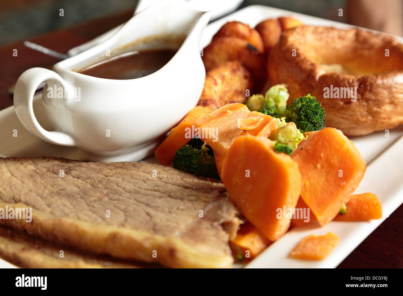 Roast of the day beef meal with vegetables potatoes Yorkshire pudding and gravy served in pub St Neots, Cambridgeshire, England Stock Photo