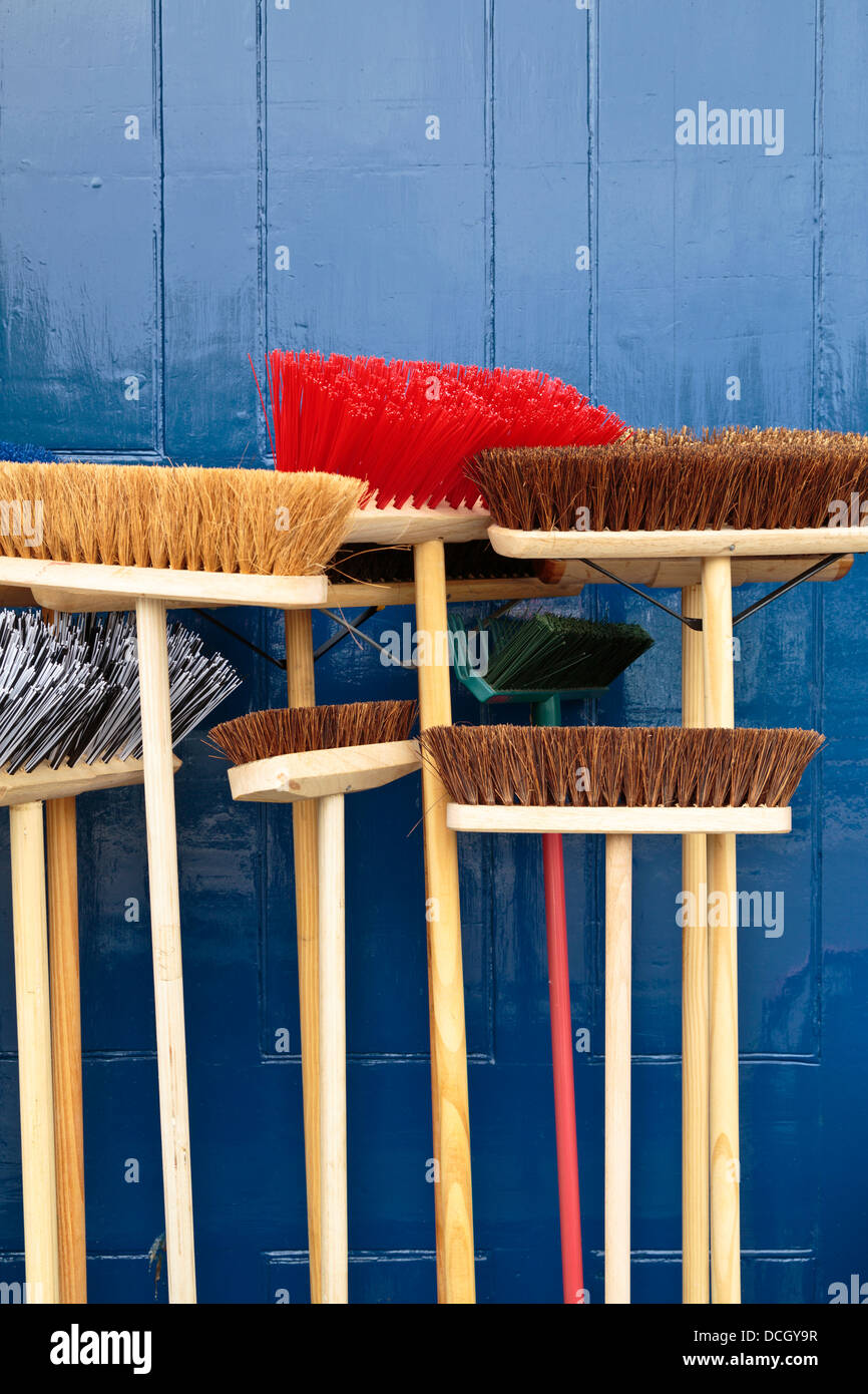 Colourful brooms for sale in front of a hardware store in St Neots
