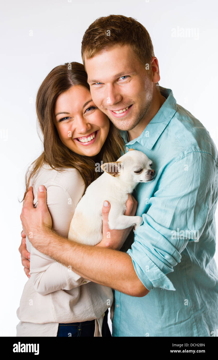 Lovely attractive couple and dog together, studio shot, white
