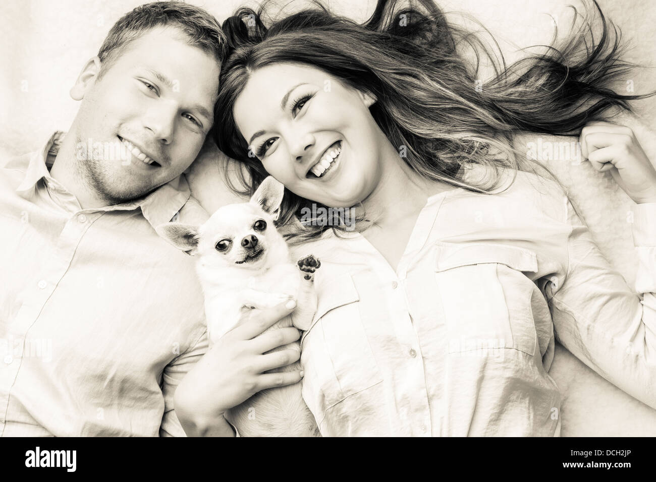 Lovely attractive couple and dog together, studio shot, white