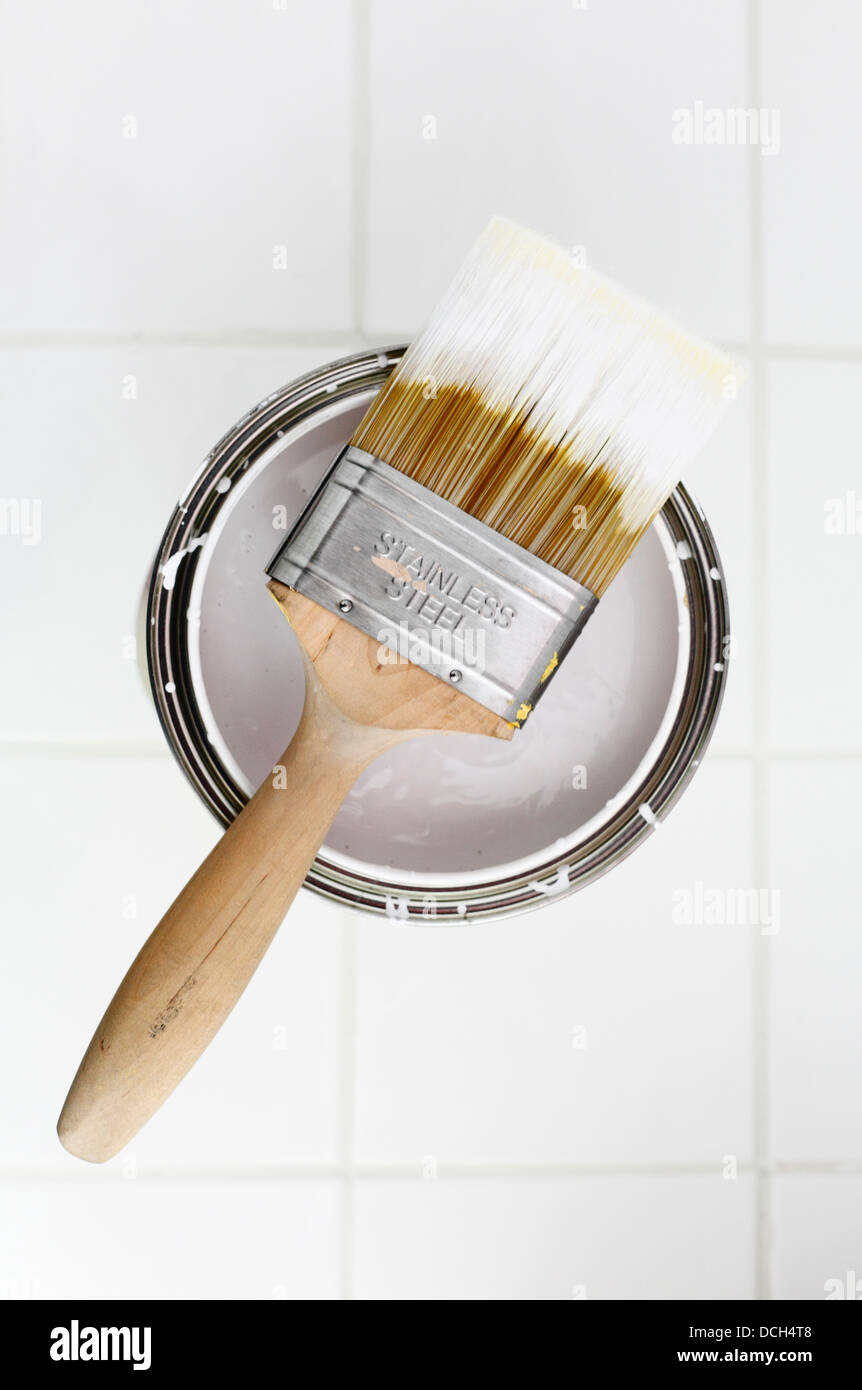 Paint brush and an open tin of white paint. Stock Photo
