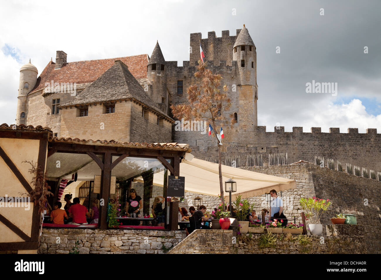 People eating at a restaurant below the Chateau de Beynac, Beynac-et-Cazenac, the Dordogne, France Europe Stock Photo