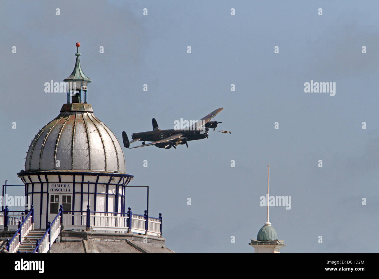 Eastbourne, UK.18th Aug, 2013. A lancaster bomber plane flies over the pier in the sunshine during the Aibourne air display in Eastbourn Credit: Keith Larby/Alamy live News Stock Photo