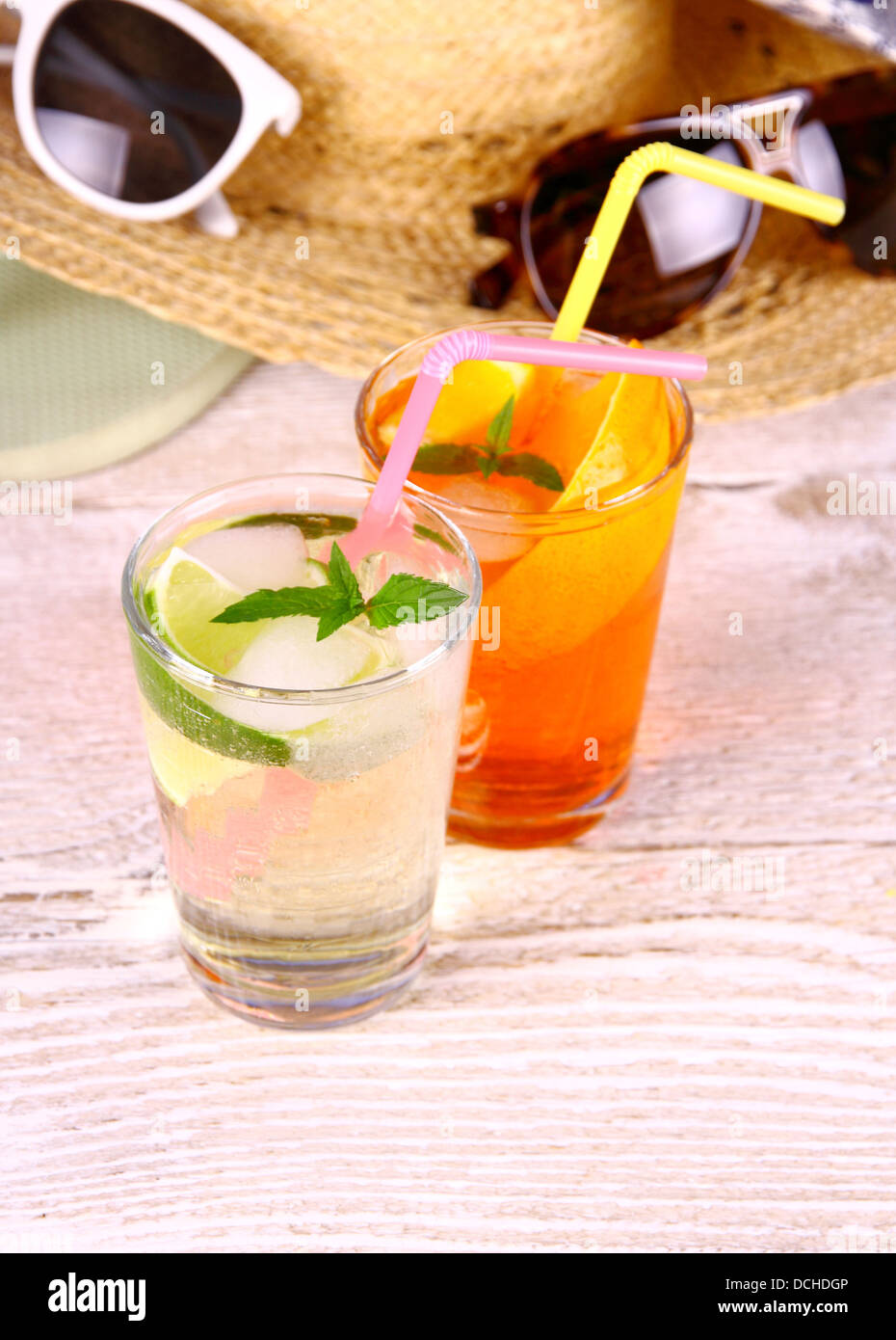 Grenn, orange cocktails with straw and holiday background, close up Stock Photo