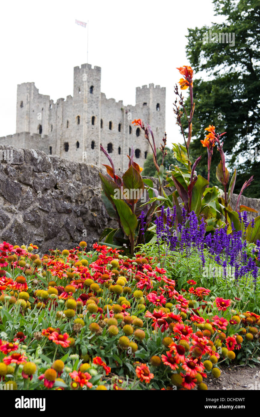 Close up of colorful flower bed against Rochester castle ruins on a grey summer day Stock Photo