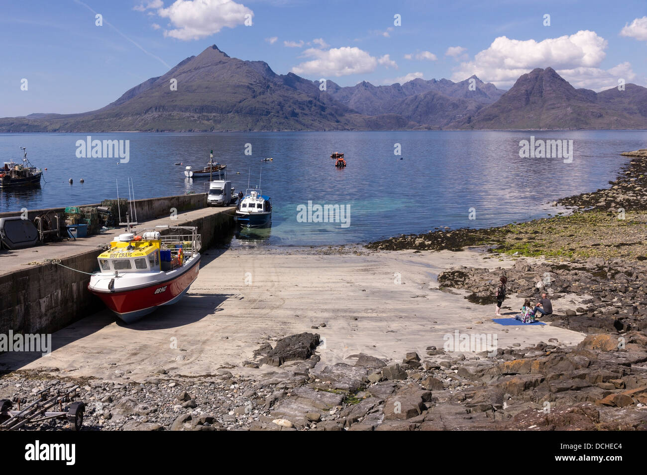 Boats moored at Elgol jetty and sandy beach with Cuillin Mountains beyond, Elgol, Skye, Scotland,UK Stock Photo