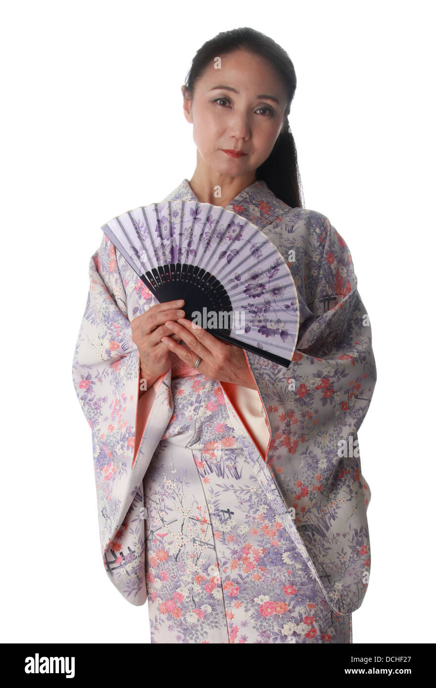 Japanese Lady Wearing a Pink and Lilac Patterned Kimono and Holding a Fan Stock Photo