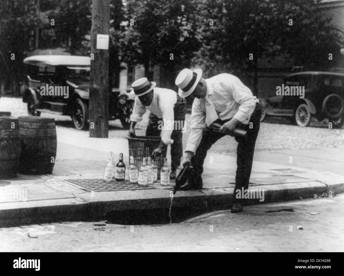 Pouring whiskey into a sewer during USA Prohibition, circa 1925 Stock Photo
