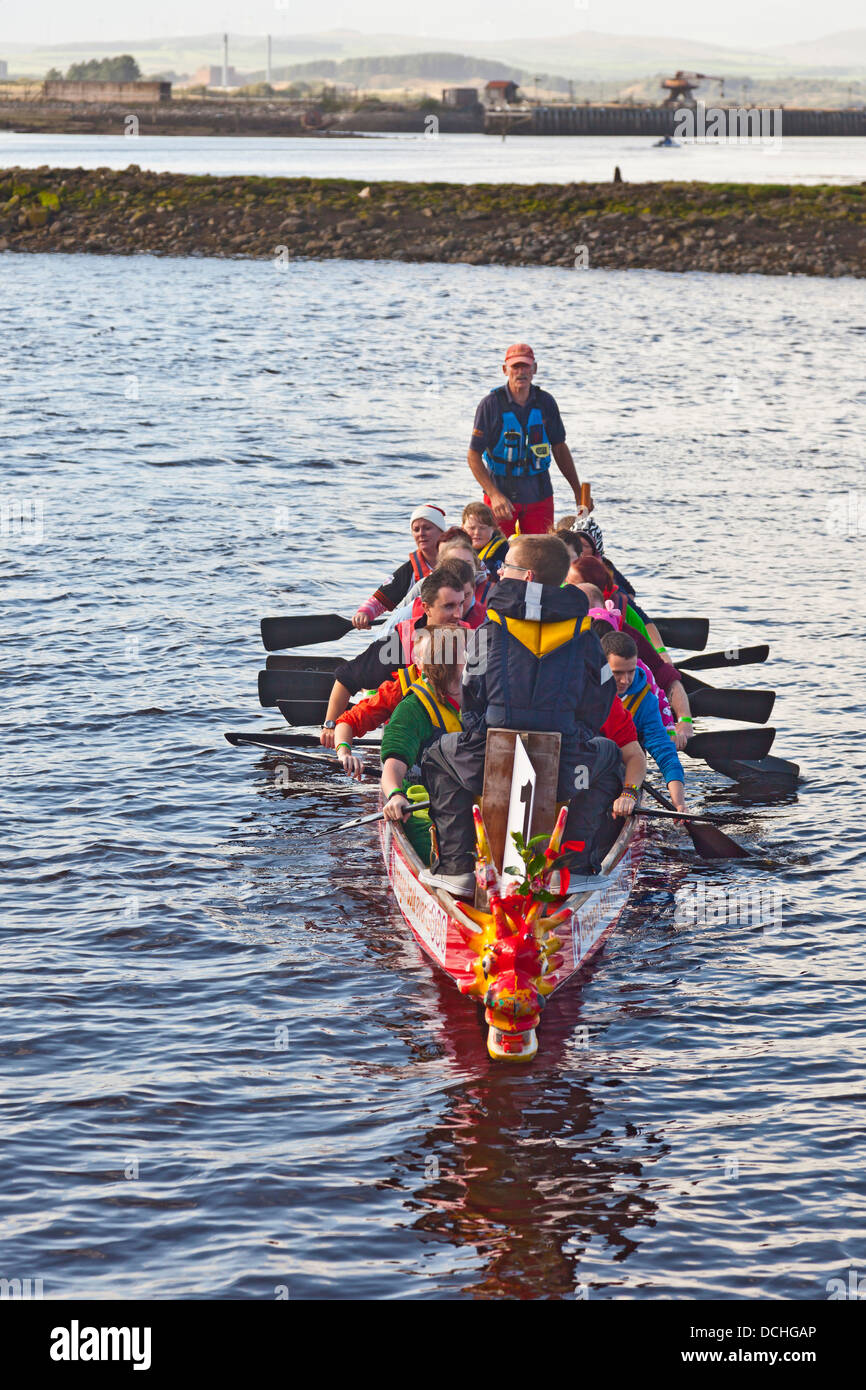 Dragon boat team rowing towards the race start point on the River ...