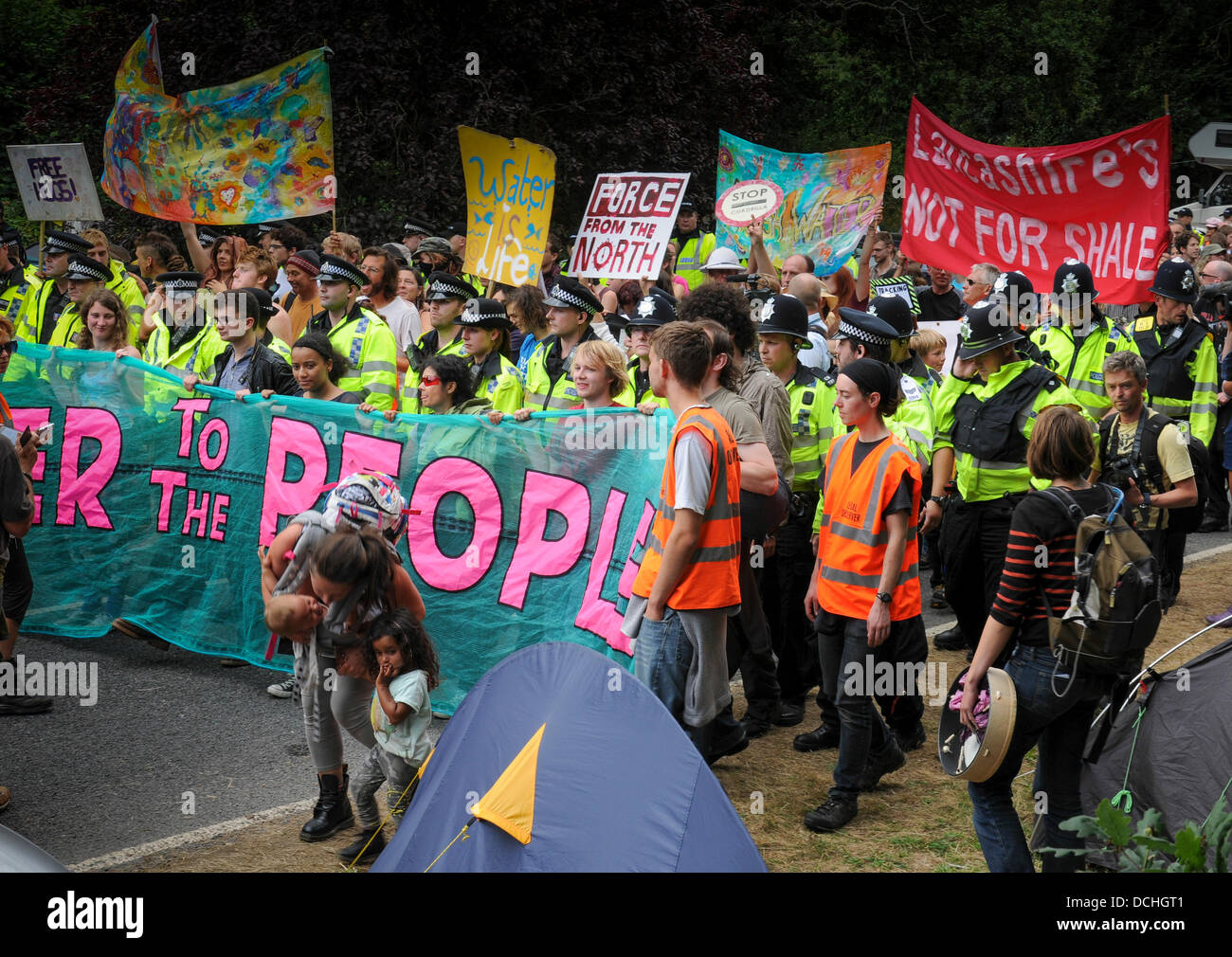 Balcombe, West Sussex, UK. 18th Aug, 2013. Balcombe, West Sussex, UK. 18th Aug, 2013. Power to the people. Environmental protesters including mothers with babes in arms parade toward Cuadrilla drilling site entrance at Balcombe © David Burr/Alamy Live News Stock Photo