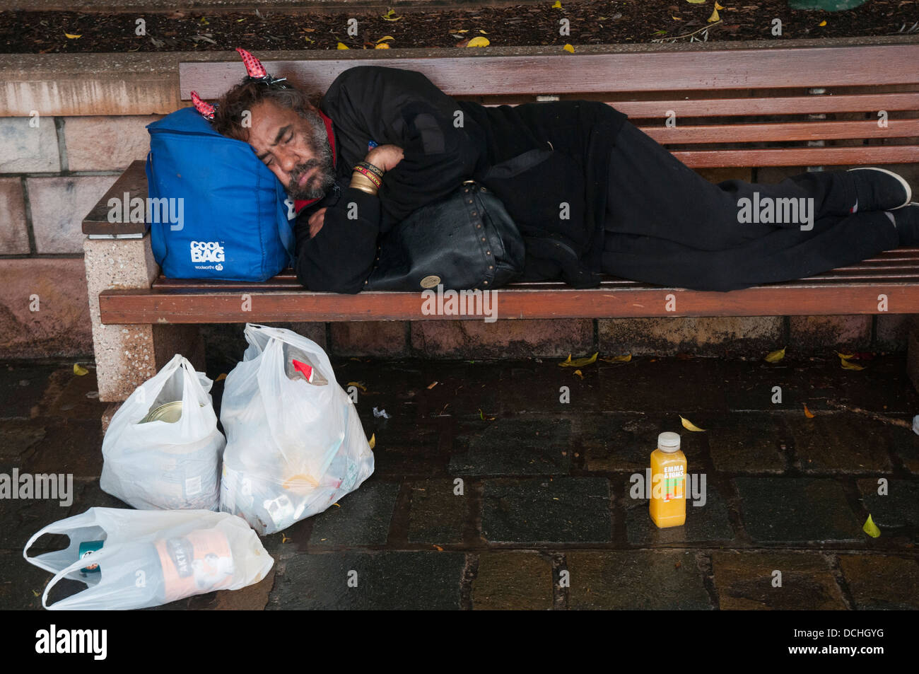 Man asleep on a park bench, Southbank, Brisbane Stock Photo