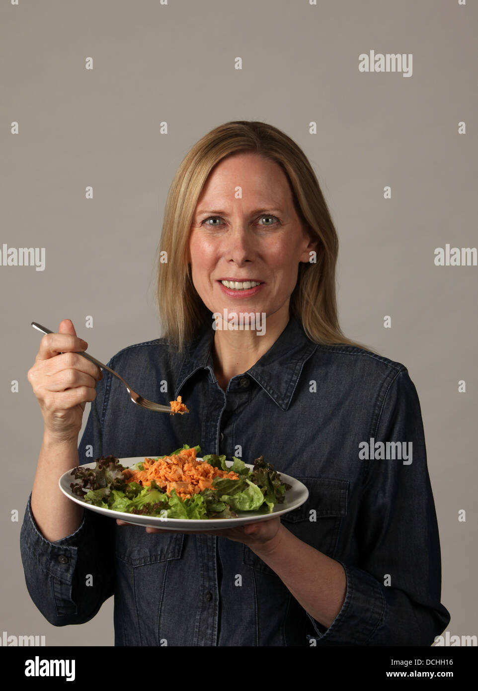 Health conscious and fit middle aged woman eating healthy green salad
