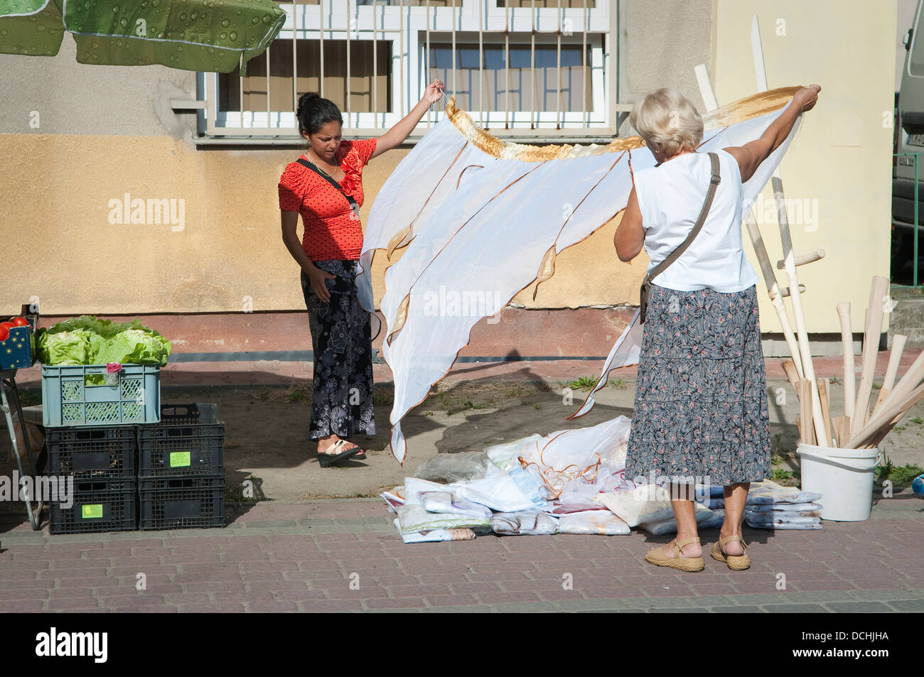 Young woman selling curtains at farmers market in Wadowice, Poland. Stock Photo