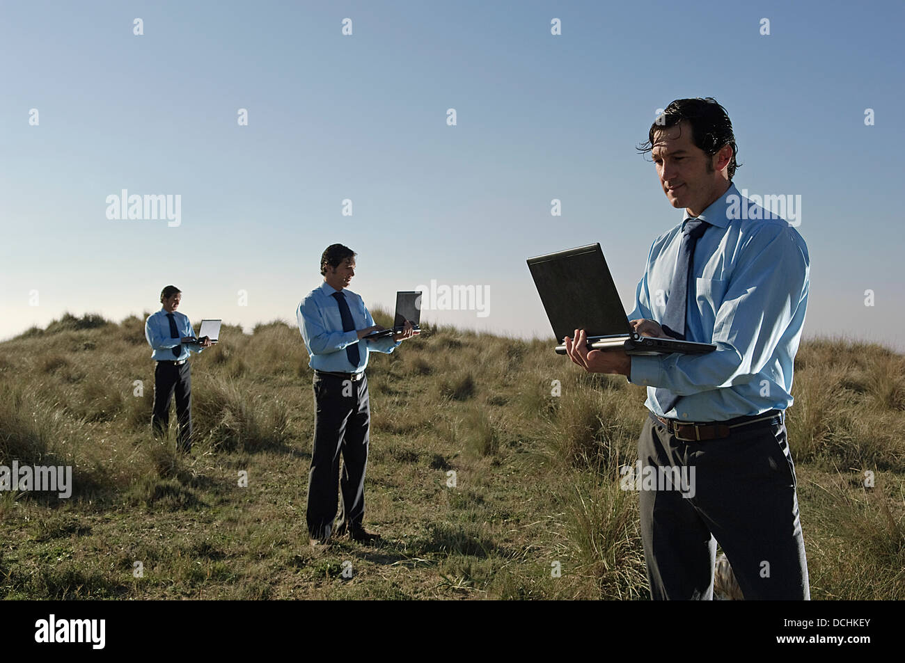 Businessmen In Field With Their Laptops Stock Photo - Alamy