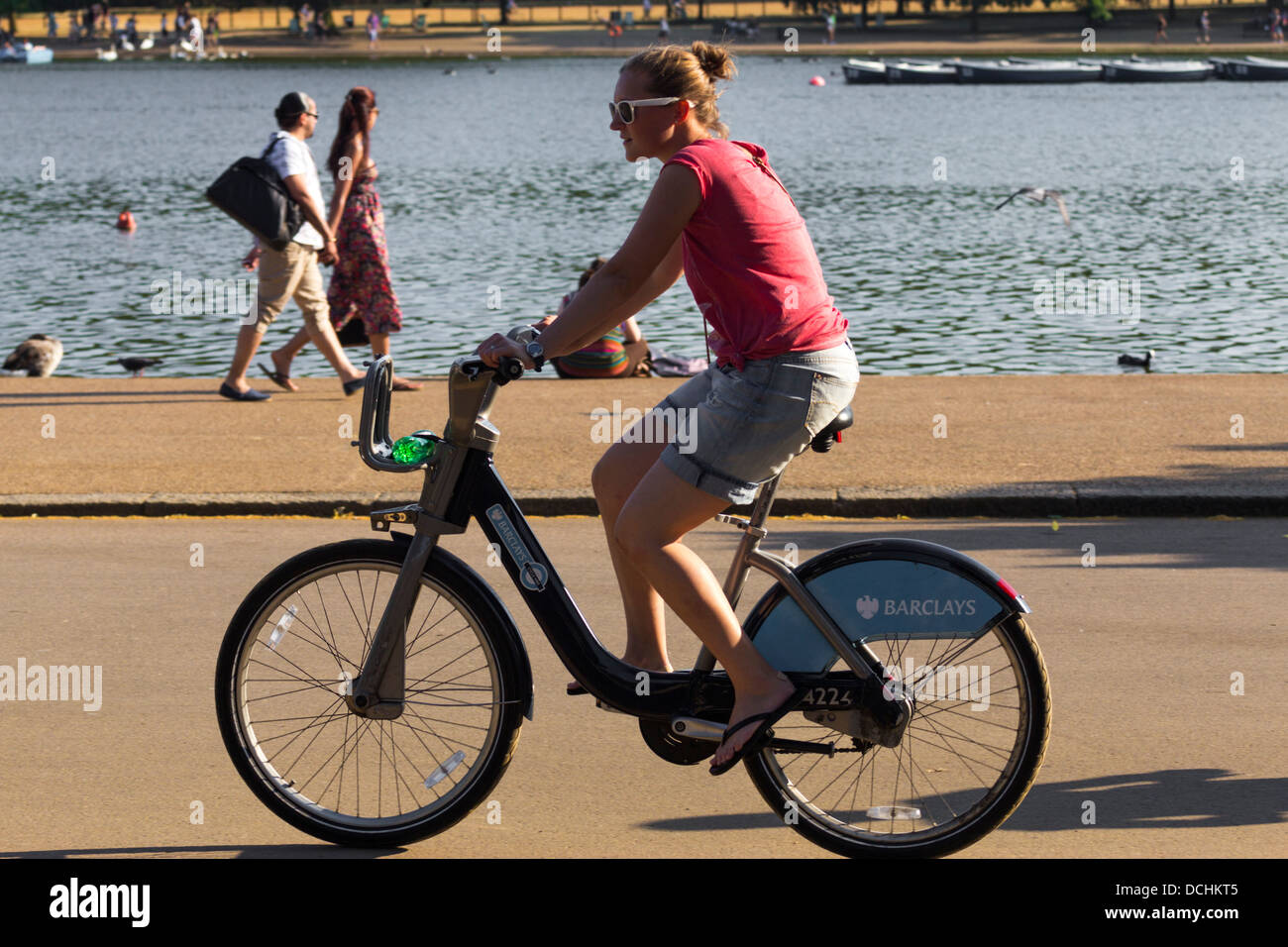 Women riding hired Cycle - Hyde Park - London [Barclays bike hire scheme] Stock Photo