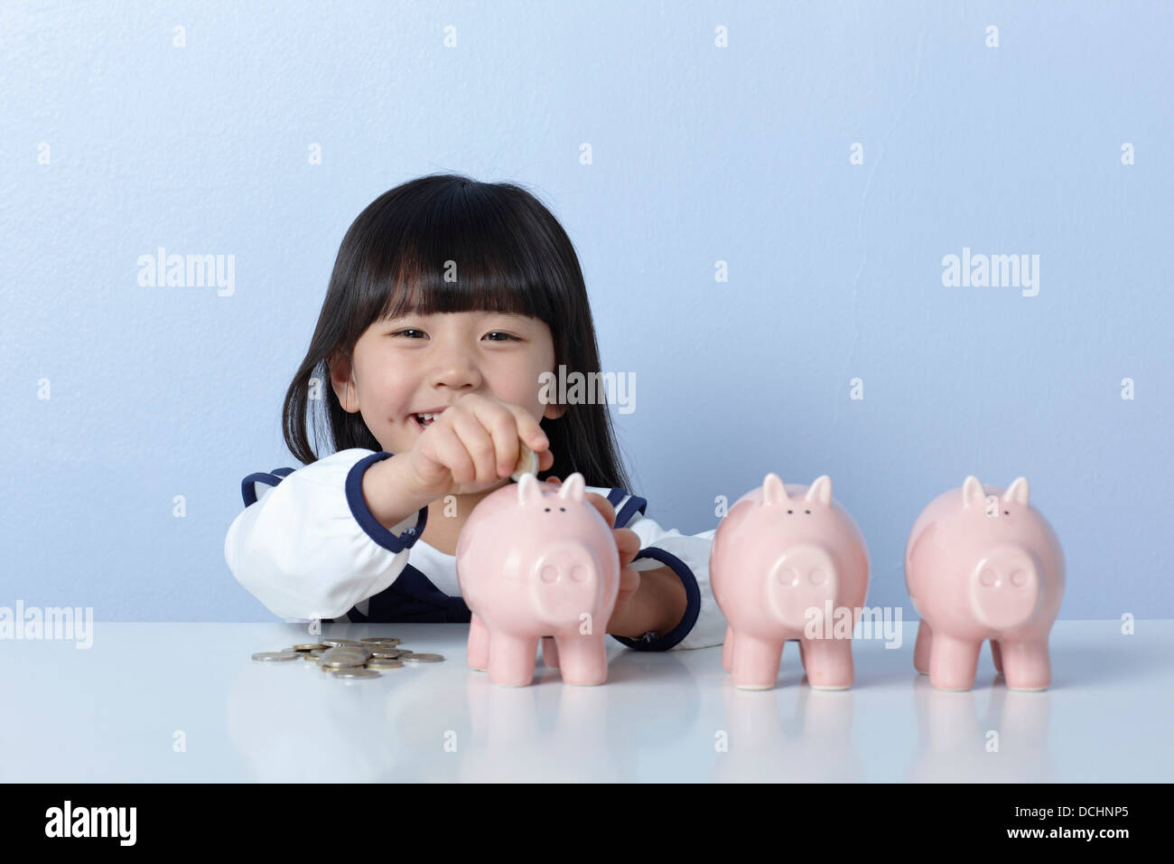 a girl with coins and piggy banks Stock Photo - Alamy