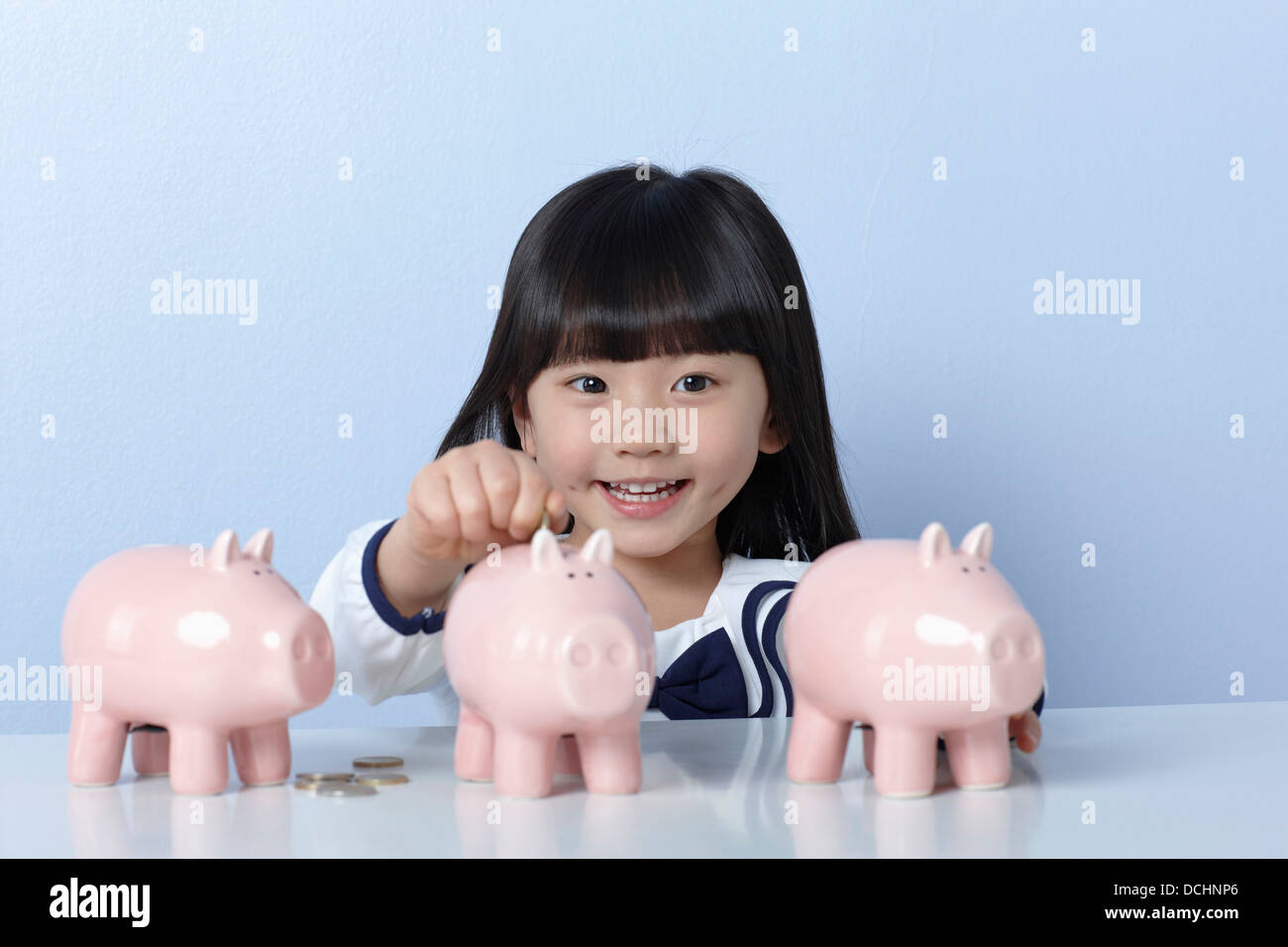 a girl with coins and piggy banks Stock Photo - Alamy