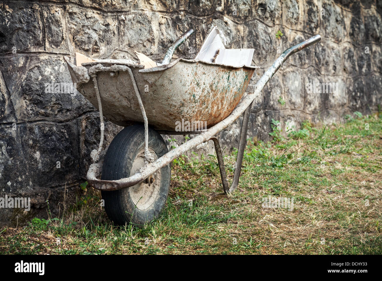 Old construction wheelbarrow stands against the wall Stock Photo Alamy