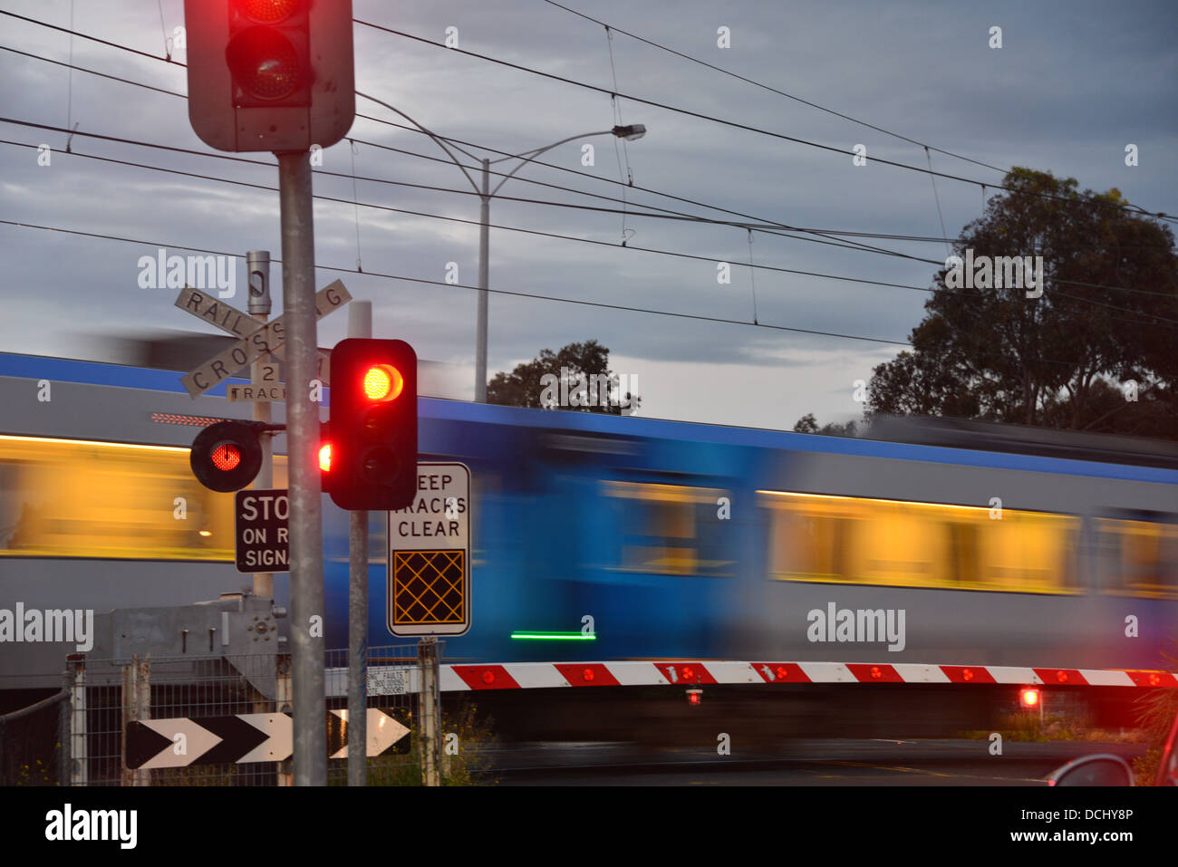 Train going through a rail crossing with the boom gate and stop light symbols Stock Photo